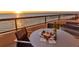 Oceanfront balcony with sunset view, table, chairs, and wine at 415 L Ambiance Dr # A801, Longboat Key, FL 34228