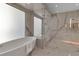 Elegant bathroom boasting marble walls and a modern soaking tub at 415 L Ambiance Dr # A801, Longboat Key, FL 34228