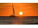 Silhouette of sailboat at sunset over calm ocean water at 415 L Ambiance Dr # A801, Longboat Key, FL 34228