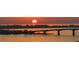 Sunset view over calm water with bridge and boat at 415 L Ambiance Dr # A801, Longboat Key, FL 34228
