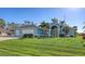 House with a large green lawn and palm trees at 42 Marker Rd, Rotonda West, FL 33947