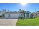 Two-car garage, light blue house, and a manicured lawn at 42 Marker Rd, Rotonda West, FL 33947