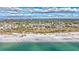 Stunning aerial view of a beachfront condo complex on a white sand beach with turquoise water and a blue sky at 420 Beach Rd # 203, Sarasota, FL 34242