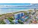 Stunning aerial view of a beachfront condo complex with tennis courts and a pool, near the ocean at 420 Beach Rd # 203, Sarasota, FL 34242
