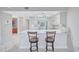 Bright kitchen with white cabinetry, breakfast bar, and tile flooring at 420 Beach Rd # 203, Sarasota, FL 34242