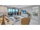 Living room with a balcony, ocean view, sofa, armchairs, and a TV at 420 Beach Rd # 203, Sarasota, FL 34242