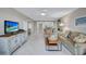 Bright and open living room with tile flooring and a view into the dining and kitchen areas at 420 Beach Rd # 203, Sarasota, FL 34242