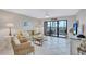Living room with sliding glass doors leading to a balcony with ocean views at 420 Beach Rd # 203, Sarasota, FL 34242