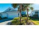 Two-car garage, light blue exterior, landscaping, and a paved driveway at 4326 Tamarind Pl, Bradenton, FL 34203