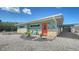Charming beach house featuring colorful accents, well-kept landscaping, and a covered carport at 4626 Gleason Ave, Sarasota, FL 34242