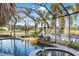 Enclosed pool and spa with a waterfall feature, offering waterfront views at 490 Capri Isles Ct, Punta Gorda, FL 33950