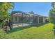 Large screened porch with grassy backyard and tropical landscaping at 4978 Cedar Oak Way, Sarasota, FL 34233