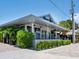 A modern, gray seafood restaurant with outdoor seating surrounded by lush tropical vegetation at 523 Reid St, Sarasota, FL 34242