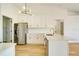 Modern kitchen with white cabinets, gold accents, and stainless steel appliances at 527 Rotonda Cir, Rotonda West, FL 33947