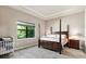 Bright bedroom with a post bed, window, and crib at 5610 Rain Lily Ct, Sarasota, FL 34238