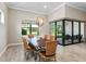 Casual dining area with wooden table, wicker chairs, and sliding glass doors to patio at 5610 Rain Lily Ct, Sarasota, FL 34238