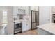 Well-equipped kitchen with wine cooler, stainless steel refrigerator, and white cabinets at 5610 Rain Lily Ct, Sarasota, FL 34238