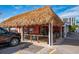 Open-air restaurant with a thatched roof, offering casual waterfront dining at 6536 Sabal Dr, Sarasota, FL 34242