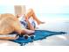 Relaxing beach scene with a person reading a book under a straw hat, ideal for vacation getaways at 1305 4Th St # 502A, Sarasota, FL 34236