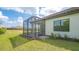 Home with screened patio, grassy yard, and tropical landscaping at 26903 Pavin Dr, Englewood, FL 34223