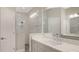 Modern bathroom boasts a quartz vanity, a large mirror, and a walk-in shower at 26903 Pavin Dr, Englewood, FL 34223