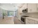Modern kitchen with white cabinets, stainless steel appliances, and quartz countertops at 26903 Pavin Dr, Englewood, FL 34223