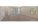 Bright and airy living area with wood-like tile flooring and sliding glass doors at 26903 Pavin Dr, Englewood, FL 34223