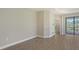 Spacious living room with wood-look tile flooring and access to outdoor patio at 26903 Pavin Dr, Englewood, FL 34223