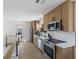 Modern kitchen with light wood cabinets, stainless steel appliances, and white tile backsplash at 303 65Th St # B, Holmes Beach, FL 34217