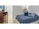 This bedroom features neutral decor and a blue patterned quilt with lots of natural light at 3115 Trustee Ave, Sarasota, FL 34243