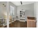Bright bedroom featuring hardwood floors, a window with blinds, and a charming glass desk at 3115 Trustee Ave, Sarasota, FL 34243