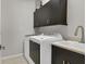Spacious laundry room featuring upper cabinets and modern washer and dryer at 3115 Trustee Ave, Sarasota, FL 34243