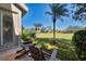 Relaxing outdoor seating area on the lanai offers serene views of the meticulously maintained backyard at 396 Lansbrook Dr, Venice, FL 34292