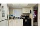 Galley kitchen with white cabinets and standard appliances at 4067 Lake Bayshore Dr # 302, Bradenton, FL 34205