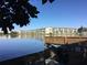 Serene lake view with dock and building reflection at 4067 Lake Bayshore Dr # 302, Bradenton, FL 34205