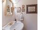 Classic bathroom with a pedestal sink, gold fixtures, and decorative wall art at 4110 Riverview Blvd, Bradenton, FL 34209