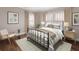 A well-lit bedroom featuring a metal-framed bed, neutral tones, and stylish decor at 4110 Riverview Blvd, Bradenton, FL 34209