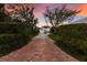 Long brick driveway leading to a charming two-story home with mature trees and manicured landscaping at 4110 Riverview Blvd, Bradenton, FL 34209