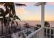Sunset water view from the balcony, featuring a boat dock, pool, and tropical landscaping at 4110 Riverview Blvd, Bradenton, FL 34209