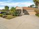 Tan house with a two-car garage and nicely landscaped yard at 4181 Lenox Blvd, Venice, FL 34293