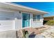 Bright teal front door entry to a light blue and white home with a two-car garage at 434 63Rd St, Holmes Beach, FL 34217