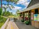 Clubhouse exterior with a wooden walkway, plants, and a pond at 4495 Longmeadow # 77, Sarasota, FL 34235