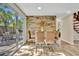 Modern glass dining table with four chairs and stone accent wall at 4564 Iola Dr, Sarasota, FL 34231