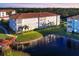 Aerial view of condos with a red-tile roof, alongside a peaceful pond and lush landscaping at 500 San Lino Cir # 511, Venice, FL 34292