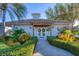 Exterior of a charming clubhouse surrounded by lush landscaping, featuring a welcoming entrance with manicured bushes at 500 San Lino Cir # 511, Venice, FL 34292