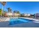 Community pool surrounded by palm trees, lounge chairs, and well-maintained condo buildings, perfect for relaxation at 500 San Lino Cir # 511, Venice, FL 34292