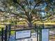 Community dog park with large oak tree and rules and regulations signs at 5397 Bartolomeo St, Sarasota, FL 34238