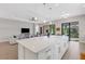 Open kitchen with large island, white cabinets, and views to living area at 5397 Bartolomeo St, Sarasota, FL 34238