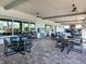 Inviting outdoor seating area with stone flooring, ceiling fans, and views of the surrounding greenery at 5397 Bartolomeo St, Sarasota, FL 34238