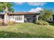 Landscaped backyard with grassy area and screened porch at 6226 Plateau Ct, Bradenton, FL 34203